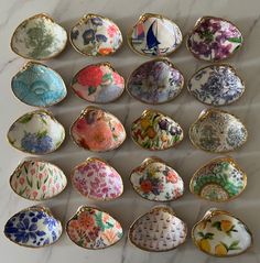 an assortment of porcelain dishes and spoons on a marble counter top, with floral designs