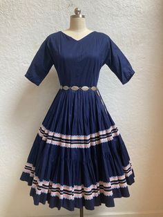 What a fun Fiesta dress! - 1950's - Fiesta dress / patio dress - No tags or labels - Navy blue cotton - 3/4 raglan sleeves - V-neck - Circle skirt - Below-the-knee length - Light pink rickrack around skirt - White, light blue, and light pink lace around skirt - Metal zipper - Metal hook and eye above zipper - Petticoat underneath not included - Belt not included **Mannequin's Measurements: Bust: 34 ½", Rib Cage: 30", Waist: 26", Hips: 35"  Measurements: - Shoulders: Undefined  - Bust: 34" - 35" - Waist: 28" - Length from shoulders to waist: 14 1/2" (short torso) - Length from waist to hem: 27 3/4" - Sleeve length: 12" (approximately due to raglan sleeves) - Arm opening: 4 3/4" across Condition: Excellent Please ensure fit before purchasing. All sales are final. No returns or exchanges. Ple 1950's Dresses, 1950s Fashion Women, Patio Dress, Fiesta Dress, Billings Mt, Short Torso, 1950s Dress, Skirt White, 50s Fashion