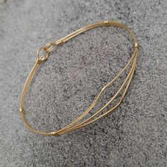 A delicate bracelet of three strands of lightweight 14kt gold filled wire pulled open in a dainty pointed design. So sweet and feminine, it would make an ideal gift for a young lady's confirmation, graduation, or birthday! The sturdy built-in hook and eye clasp is easy to get on and off by yourself. Choose the best size from the variations for a perfect fit! Add on a jewelry polishing cloth to keep your bracelet--and ALL your jewelry--shiny clean! https://www.etsy.com/listing/732310828/jewelry-p Adjustable Gold Wrap Bracelet, Gold Adjustable Wrap Bracelet, Adjustable Gold Wrap Bracelet For Everyday, Adjustable Gold Minimalist Wrap Bracelet, Adjustable Dainty Gold Bangle Bracelet, Adjustable Delicate 14k Gold-filled Bracelets, Adjustable Minimalist Brass Bracelets, Minimalist Adjustable Brass Bracelets, Minimalist Adjustable Brass Bracelet