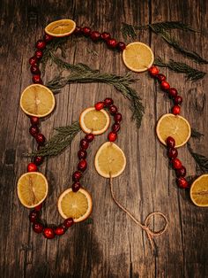 oranges and cranberries are arranged in the shape of a tree on a wooden table