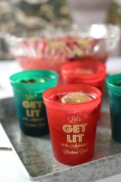 four cups sitting on top of a counter in front of a bowl filled with food