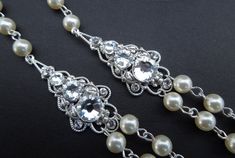 "This charming necklace has two pendants decorated with graduated Swarovski crystals and Swarovski pearls in ivory/cream. Pearls measure 6 mm and are hand linked. Necklace measures approximately 17 1/4\" long inner strand. Finished off with a lobster clasp and 2\" extender chain for additional length. Pearls can be substituted with white color and size can be adjusted. Length can be extended up to 18\" long inner strand,without extra charge if specified at the time of ordering. Let me know at ch Wedding Rhinestone Necklace With Pearl Chain, Elegant Pearl Necklace With Rhinestones For Wedding, Elegant Bridal Necklace With Pearl Chain And Crystal, Wedding Pearl Necklace With Rhinestones, Elegant Silver Rhinestone And Pearl Necklace, Elegant Backdrop Necklace With Rhinestones For Gift, Elegant Rhinestone Necklace With Pearl Chain, Elegant Backdrop Necklace With Rhinestones, Elegant Pearl Necklace With Rhinestones For Gift