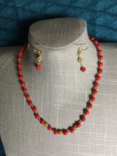 "Necklace of red shell pearls and gold accents. Finished with magnetic clasp.Earrings to match for pierced ears. Necklace 18\". Earrings 1.5\" long." Festive Red Pearl Necklace With Round Beads, Elegant Red Necklace With Gold Beads, Red Jewelry With Gold Beads For Gifts, Gold Beaded Necklaces With Red Coral Round Beads, Gold Beaded Necklace With Polished Red Coral, Festive Red Coral Necklace, Gold Beaded Red Coral Necklaces, Gold Beaded Necklaces With Red Coral, Red Jewelry With Gold Beads For Jewelry Making