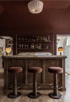 a bar with three stools in front of it