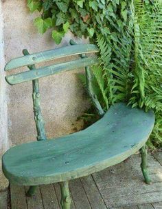 a green bench sitting next to a plant