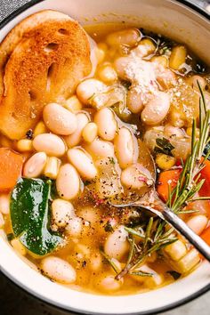 a white bowl filled with beans, carrots and bread