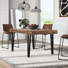 a dining room table with chairs and a bowl of fruit on the table next to it