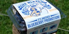 a box of blueberries sitting on top of a wooden post