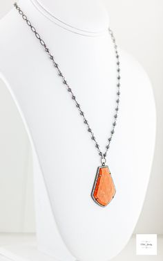 Stand out in this beautiful eye-catching burnt orange resin, hematite and cubic zirconia necklace. Bold and bright it is ready for your next event and bound to get you noticed! The beautiful uniquely shaped burnt orange resin bezel has shimmering ribbons of saffron yellow throughout and it is framed by sparkling cubic zirconia stones.Stunning, bright and shimmering faceted cherry burnt orange resin framed by black gold-plated sterling silver bezel that is studded with sparkling cubic zirconia. Black gold-plated short and long oval link chain. Beautiful shimmering silvery black hematite beads wrapped in black gold-plated chain. Gunmetal-plated brass lobster clasp for a secure and comfortable fit. 18.5 inches long. Only one available! Make this gorgeous limited edition necklace yours today! Orange Gemstone Pendant Jewelry, Orange Gemstone Necklaces As A Gift, Orange Gemstone Pendant Necklace, Orange Carnelian Gemstone Necklace, Orange Faceted Jewelry Gift, Elegant Orange Pendant Necklaces, Elegant Long Orange Necklace, Orange Carnelian Pendant Jewelry, Orange Large Pendant Jewelry