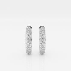 The Bombë Micro Huggie is a luxurious take on an everyday favorite. A miniature version of a classic hoop earring, these 14K gold diamond huggie earrings exude elegance and contemporary style. Three rows of lab grown pave diamonds embellish the curved shape of the earrings, encouraging you to dazzle from every angle. Luxury Dazzling Round Huggie Earrings, Luxury Oval Huggie Earrings For Everyday, Classic White Hoop Earrings With Halo Design, Luxury Pave Setting White Gold Huggie Earrings, Luxury White Gold Huggie Earrings With Pave Setting, Luxury Round Huggie Earrings With Pave Setting, Luxury White Hoop Earrings With Brilliant Cut, Everyday Luxury White Gold Hoop Earrings With Pave Setting, Luxury White Brilliant Cut Hoop Earrings