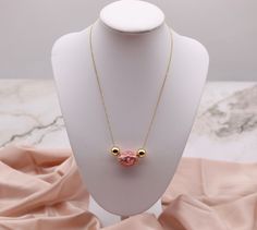 This gold necklace is a great way to add a touch of whimsy to your everyday wardrobe. It features a horizontal pink tie dye egg shape pendant that is sure to attract attention. The necklace is made of a high-quality gold alloy that is hypoallergenic and tarnish-resistant. It is easy to put on and take off, and it is comfortable to wear all day long. Pink Pendant Chain Necklace Gift, Pink Pendant Chain Necklace As Gift, Handmade Pink Gold-plated Necklaces, Handmade Pink Gold-plated Necklace, Pink Pendant Necklace With Adjustable Chain, Handmade Pink Chain Necklace As Gift, Pink Oval Pendant Necklace Gift, Pink Adjustable Round Pendant Necklace, Adjustable Pink Gold Necklaces As A Gift