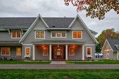 a large gray house with lots of windows on the front and side of it's roof