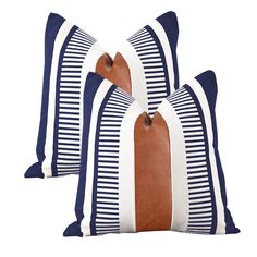 two blue and white striped pillows with brown leather trims on each pillow, one in the