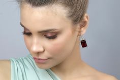 Make a statement with these gorgeous Rectangular Garnet Gold Dangle Earrings. Measuring 13x18mm, these earrings feature prong-set semiprecious garnet stones, making them a perfect accessory to celebrate your January birthstone. The gold finish adds a touch of luxury, making these earrings a great choice for special occasions. These handmade earrings are crafted with high-quality materials and are sure to last for years to come. January birthstone garnet earrings Prong set semiprecious stones Han Elegant Garnet Drop Earrings, Elegant Earrings With Rectangular Stone For Anniversary, Elegant Jewelry With Rectangular Stone For Formal Occasions, Elegant Formal Jewelry With Rectangular Stone, Elegant Anniversary Earrings With Rectangular Stone, Elegant Rectangular Stone Formal Jewelry, Garnet Gemstone Earrings, Elegant Rectangular Stone Earrings, Elegant Jewelry With Rectangular Stone