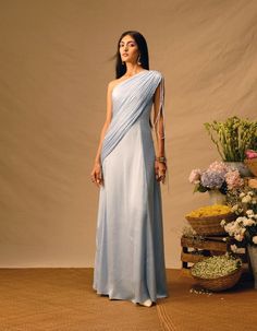 Elevate your style with our Powder Blue Ruching Saree Dress, a harmonious fusion of modern and ethnic charm. The traditional saree drape-like pallu adds an authentic touch, while the fitted upper body seamlessly transitions into a flared dress. The finely ruched panel across the body makes it ideal for any fusion outfit inspiration. Embrace sophistication and versatility with this exquisite dress, perfect for making a memorable statement at any occasion.Product details: Material - Modal Satin, V