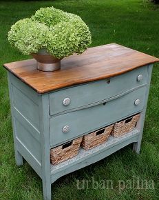 an old dresser with drawers and a potted plant on top