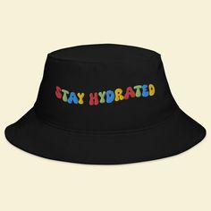 Keep the festival spirit alive with our "Stay Hydrated" Bucket Hat. This hat isn't just an accessory; it's a reminder to take care of yourself and spread positive vibes while you groove to the beats of EDM, Rave, and your favorite music festivals. 🎵 Key Features 🎵 Premium quality fabric for all-day comfort Unique design that promotes staying hydrated and positive vibes Trendy bucket hat style that adds flair to your festival attire One size fits most for convenient wear 🌈 Festival Vibes 🌈 Wh Affordable Cap For Music Festival, Black Fun Bucket Hat For Summer, Fun Black Bucket Hat For Summer, Fun Black Summer Bucket Hat, Adjustable Flat Brim Sun Hat For Streetwear, Trendy Adjustable Hats For Music Festival, Adjustable Black Bucket Hat With Letter Print, Fun Adjustable Hats For Streetwear, Casual Bucket Hat For Music Festival