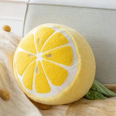 a lemon shaped pillow sitting on top of a couch