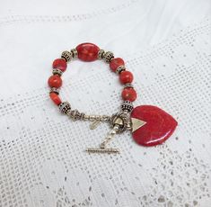 Solid Silver & Red Coral Bead Bracelet Toggle Catch Red Coral Heart Drop By The Designer Doug Paulus For QVC English Silver Import Marks. A beautiful bracelet the centre has an oval coral bead with silver beads and round coral beads the catch is a toggle and has a large coral drop heart. The silver is marked for Doug Paulus 925 and silver import marks for QVC. I have tested the Coral. The bracelet measures 8 inches long the heart drop measures 1 and a 1/4 inches long x 1 and 1/8th inches wide the length does not include the large chain bail. The bracelet is in very good condition. Any questions please ask. Thanks For Looking. Red Beaded Heart-shaped Bracelets, Red Bracelets With Heart Charm And Round Beads, Bohemian Red Heart-shaped Bracelet, Hand-strung Heart Shaped Jewelry Gift, Hand-strung Heart Shaped Jewelry For Gift, Hand-strung Heart Jewelry As Gift, Hand-strung Heart Jewelry For Gift, Red Adjustable Charm Bracelet With Heart Charm, Adjustable Red Charm Bracelet With Heart Charm