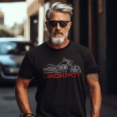 an older man with grey hair and sunglasses wearing a black jackpot t - shirt