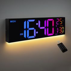 an alarm clock is lit up with the time on it's display and remote control