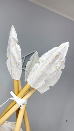 three wooden sticks with white and gold designs on them, tied together in a basket