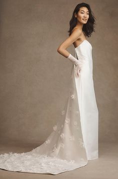 a woman in a white wedding dress posing for a photo with her hands on her hips