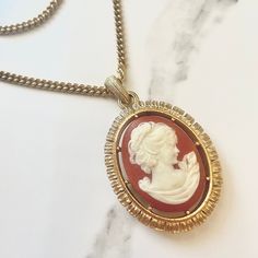 Great condition vintage Cameo of a peaceful , graceful women. Beautiful unique details through out this charm.  I do ship out same day, you will receive item very quickly. Please check out all my other vintage jewrwly in my personal shop.  Thank you so much for your support Oval Necklaces For Vintage Collection, Vintage Gold Jewelry For Vintage Fashion, Vintage Initial Pendant Necklace, Vintage Brass Necklace, Retro Gold Cameo Jewelry, Vintage Cameo Medallion Necklace, Vintage Cameo Necklace In Antique Gold, Vintage Red Locket Necklace, Elegant Luxury Cameo Necklace