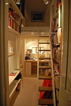 a narrow room with bookshelves and stairs leading to the loft bed in it