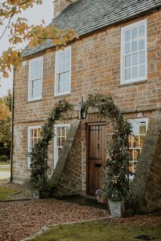 an old brick house with ivy growing on it's front door and window frames