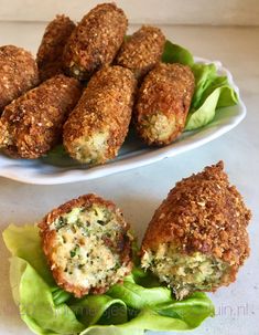 some food is sitting on a plate next to lettuce and meatballs with sauce