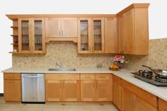 a kitchen with wooden cabinets and white counter tops, stainless steel dishwasher on the left