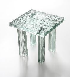 a small glass table with two legs on the bottom and one leg up against it