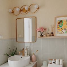 a white sink sitting under a mirror in a bathroom