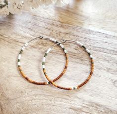 White, olive, mustard, and rust seed bead earrings, 1 ³/⁴ inches in diameter.  Nickel free hoops. Choose gold or silver hoops. Return to shop 👇 https://wyldsparrowjewelry.etsy.com PLEASE MAKE SURE YOUR ADDRESS IS ENTERED CORRECTLY. IF YOU ARE DOING A GUEST CHECKOUT PLEASE PLEASE DOUBLE CHECK YOUR ADDRESS AND YOUR EMAIL. THANK YOU! *All feathers are cruelty free.  All hooks are lead and nickel free. All leather is genuine leather. *Please feel free to contact me with ANY questions or custom crea Bohemian Heishi Beads Small Hoop Earrings, Bohemian Small Hoop Heishi Bead Earrings, Bohemian Heishi Beads Hoop Earrings, Bohemian Hoop Earrings With Heishi Beads, Bohemian Hoop Beaded Earrings With Heishi Beads, Bohemian Heishi Beaded Hoop Earrings, Bohemian Hoop Earrings With Tiny Beads, Handmade Bohemian Hoop Beaded Bracelets, Bohemian Heishi Beaded Earrings With Ear Wire