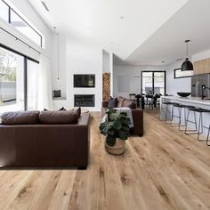 a living room filled with furniture next to a kitchen and an open concept dining area