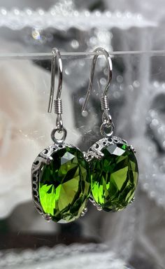 "Simulated Green Peridot Earrings Edward Design#70 Custom Made These are Victorian/Edwardian design earrings in sterling silver set with high-quality simulated Green Peridot gemstones. Each stunning 5ct Green gem is 14mm long (9/16th\") and 10mm in width (3/8th\"). The earrings are 1 1/4th inches long. Notice the beautiful swag/swirl filigree pattern of the setting. A gift box is included and all items are shipped in the gift box for safekeeping. Feel free to ask questions and thanks for looking Green Oval Nickel-free Earrings, Green Oval Earrings For Formal Occasions, Classic Green Sterling Silver Earrings, Green Oval Earrings For Anniversary, Oval May Birthstone Earrings, Green Filigree Earrings For Formal Occasions, Green Formal Filigree Earrings, Green Oval Earrings As Gift, Green Oval Earrings For Gift