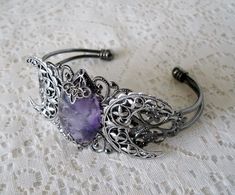 This beautiful silver plated cuff bracelet has a silver plated triple moon design and an amethyst setting with silver plated embellishments. Adjustable. Mystical Jewelry Bracelet Gift, Adjustable Mystical Silver Bracelet, Adjustable Silver Mystical Bracelet, Silver Spiritual Metal Cuff Bracelet, Spiritual Silver Metal Cuff Bracelet, Gothic Silver Bracelet, Silver Gothic Bracelets For Festival, Silver Gothic Bangle, Bohemian Silver Wire Wrapped Crystal Bracelet