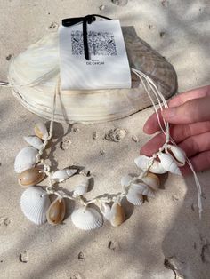 Embrace the essence of the ocean with our Boho Seashell Choker Necklace—an exquisite accessory for beach lovers and free spirits alike. Perfect for your next beach vacation, a seaside wedding, or simply adding a touch of coastal charm to your everyday look, this necklace captures the beauty of the sea in a minimalist, boho-inspired design. Handcrafted with natural seashells, each choker is a unique piece of ocean treasure that resonates with the tranquil vibes of the beach. Its simple yet elegan Adjustable White Jewelry For The Beach, Handmade Ocean-inspired Sand Colored Jewelry, Ocean-inspired Shell Necklace Gift, Handmade Sand-colored Ocean-inspired Jewelry, Ocean-inspired Necklaces For Summer Gifts, Ocean-inspired Necklaces As Summer Gifts, White Jewelry For Beach Season Gift, White Shell Jewelry For Beach Season, Adjustable White Shell With Ocean-inspired Style