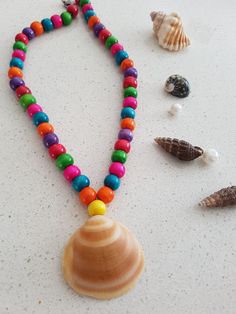 A handcrafted necklace featuring natural sea shells and a variety of colorful beads. An ideal gift for any occasion, it pairs well with any outfit. Bohemian Shell With Colorful Beads For Gift, Colorful Shell Beaded Necklaces, Bohemian Shell-shaped Beaded Necklace, Bohemian Beaded Multicolor Shell, Bohemian Multicolor Beaded Shell, Beach Shell Necklace With Colorful Beads, Colorful Beaded Shell-shaped Necklace For Beach, Multicolor Beaded Shell For Beach, Multicolor Shell Necklace As A Gift