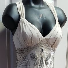 a mannequin wearing a white dress with silver sequins on it's chest