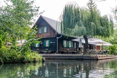 a house sitting on top of a lake next to trees