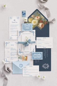 the wedding stationery is laid out on top of each other, with blue and white accents