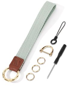 a green belt with gold rings and two pairs of scissors next to it on a white surface