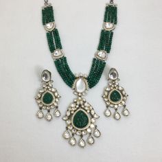 Make a statement with this exquisite green Kundan long necklace. Featuring a Victorian-inspired Polki pendant with a dazzling emerald, this Sabyasachi-inspired piece is crafted in premium dual-tone Jadau. Perfect for any special occasion, it combines timeless elegance with luxurious craftsmanship to enhance your unique style. *𝐏𝐑𝐎𝐃𝐔𝐂𝐓 𝐃𝐄𝐓𝐀𝐈𝐋* * Material: Brass * Plating: Gold Plated * Stone: Kundan, Polki & Emerald. *𝐃𝐈𝐌𝐄𝐍𝐒𝐈𝐎𝐍𝐒* *Necklace* * Weight: 71 gm * One Side Length Elegant Green Kundan Necklace With Meenakari, Green Stone Work Necklace For Gift, Green Stone Work Necklaces For Gifts, Gift Green Stone Work Necklace, Green Emerald Kundan Necklace With Gemstones, Elegant Green Chandbali Kundan Necklace, Emerald Necklace With Stone Work For Celebration, Luxury Green Meenakari Jewelry, Green Pendant Temple Necklace For Festive Occasions