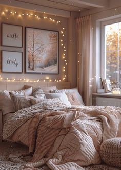 an unmade bed in a bedroom with lights on the wall and pictures above it