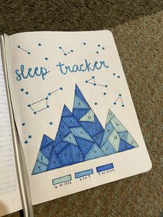 an open notebook with the words sleep tracker written in blue ink on top of it