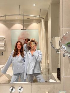 three women in pajamas are taking a selfie in the bathroom mirror with their reflection