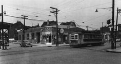 an old black and white photo of a trolley on the street in front of buildings