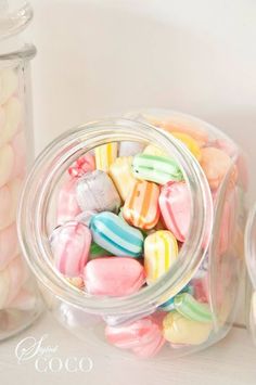 a jar filled with lots of candy next to a container full of marshmallows